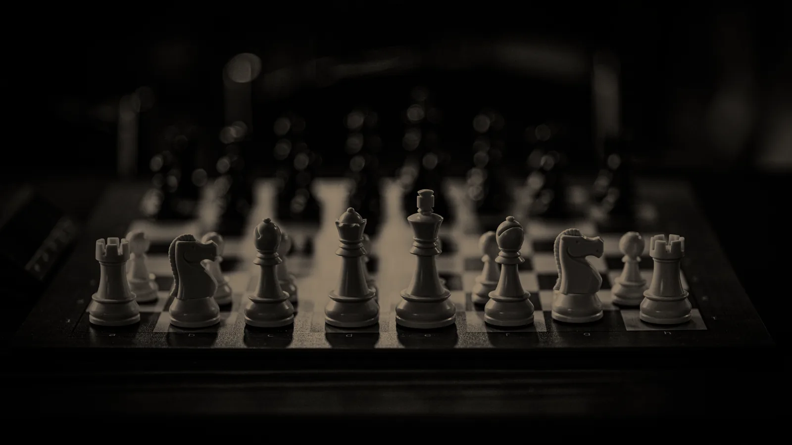 A chessboard set up before the first move, the white pieces sharp in front and the black pieces soft behind them